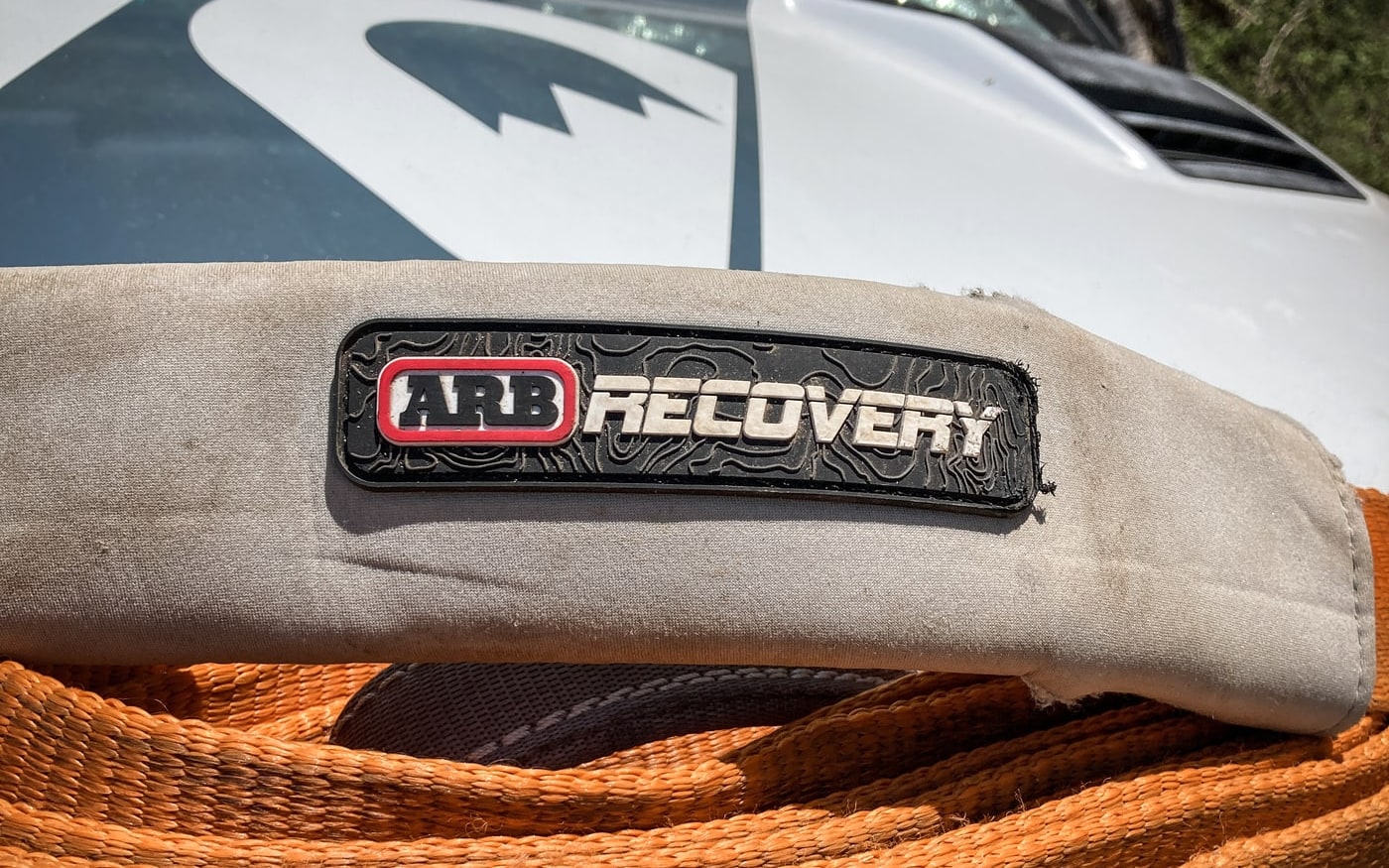 An orange ARB recovery strap resting on a vehicle bumper