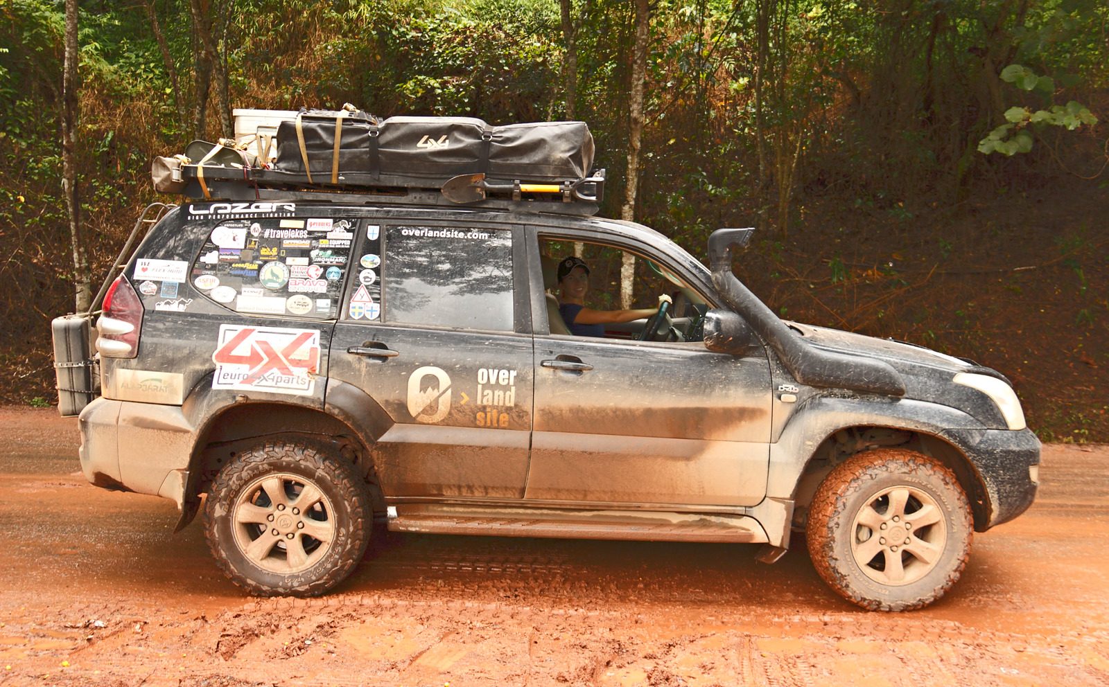 Evelin at the wheel of the Overlandsite Toyota Land Cruiser Prado on a red laterite road