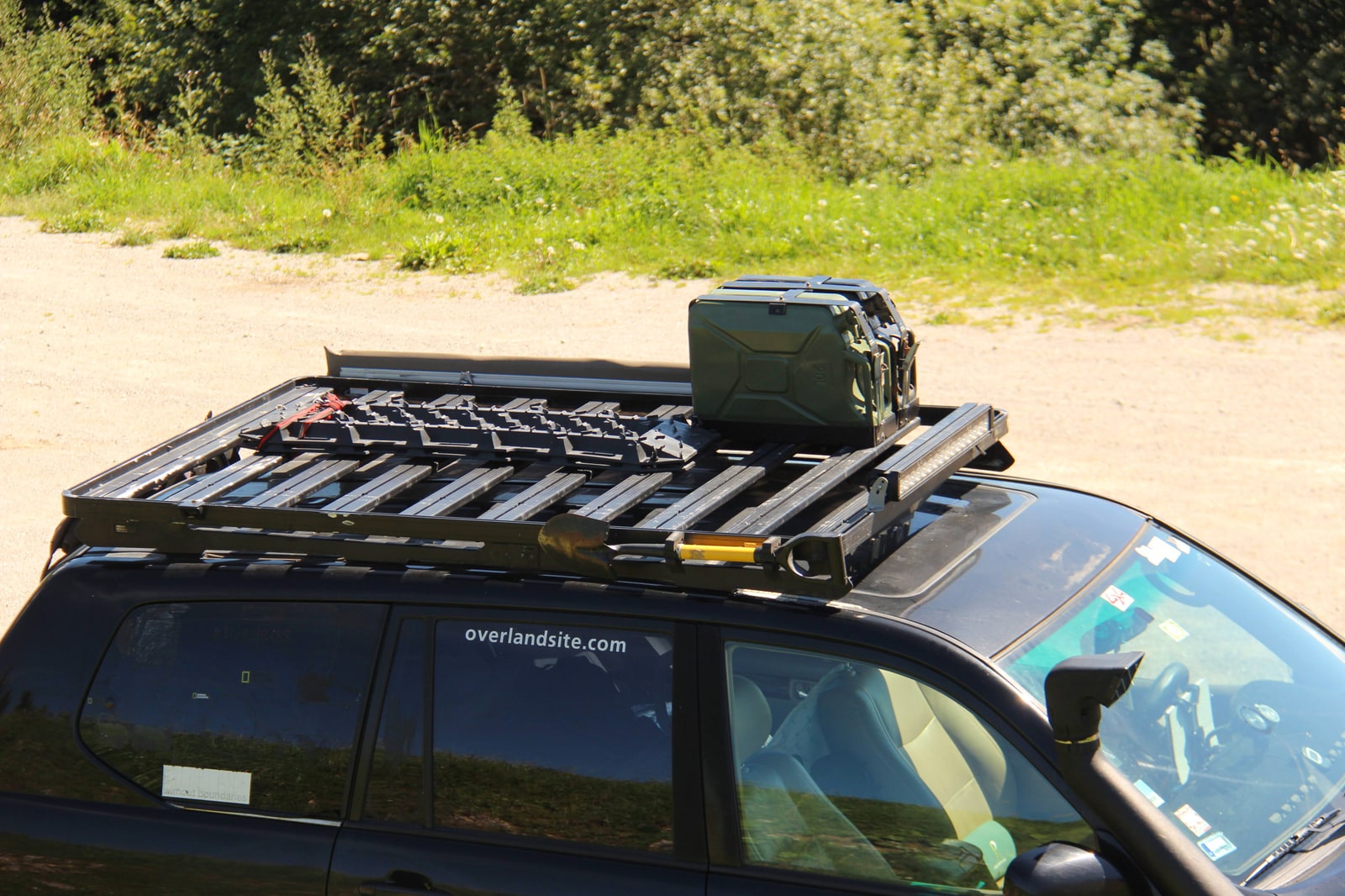 A roof rack loaded with a jerry can, traction boards and a shovel